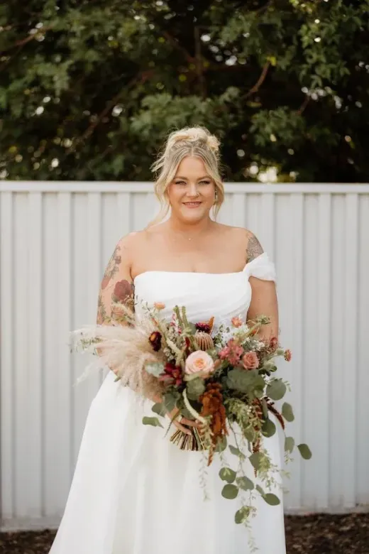Bride holding a bouquet in an off-shoulder gown, soft bridal glam