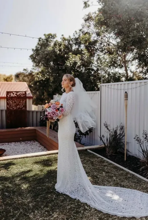 Bride outdoors in a fitted lace gown